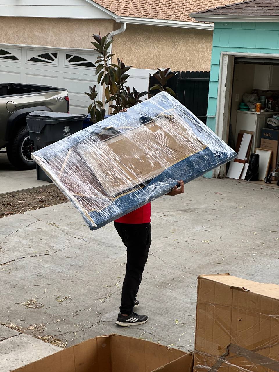 Wrapped mattress being loaded during a house move